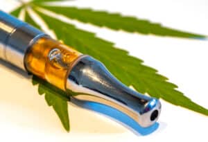 CBD vaporizer with a cannabis leaf isolated on white background