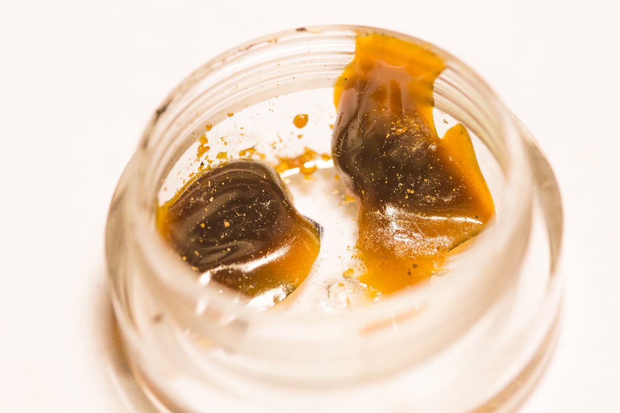 Cannabis wax concentrate in clear plastic container.