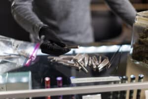 A budtender handles pre-rolls in a retail cannabis shop in Oregon.